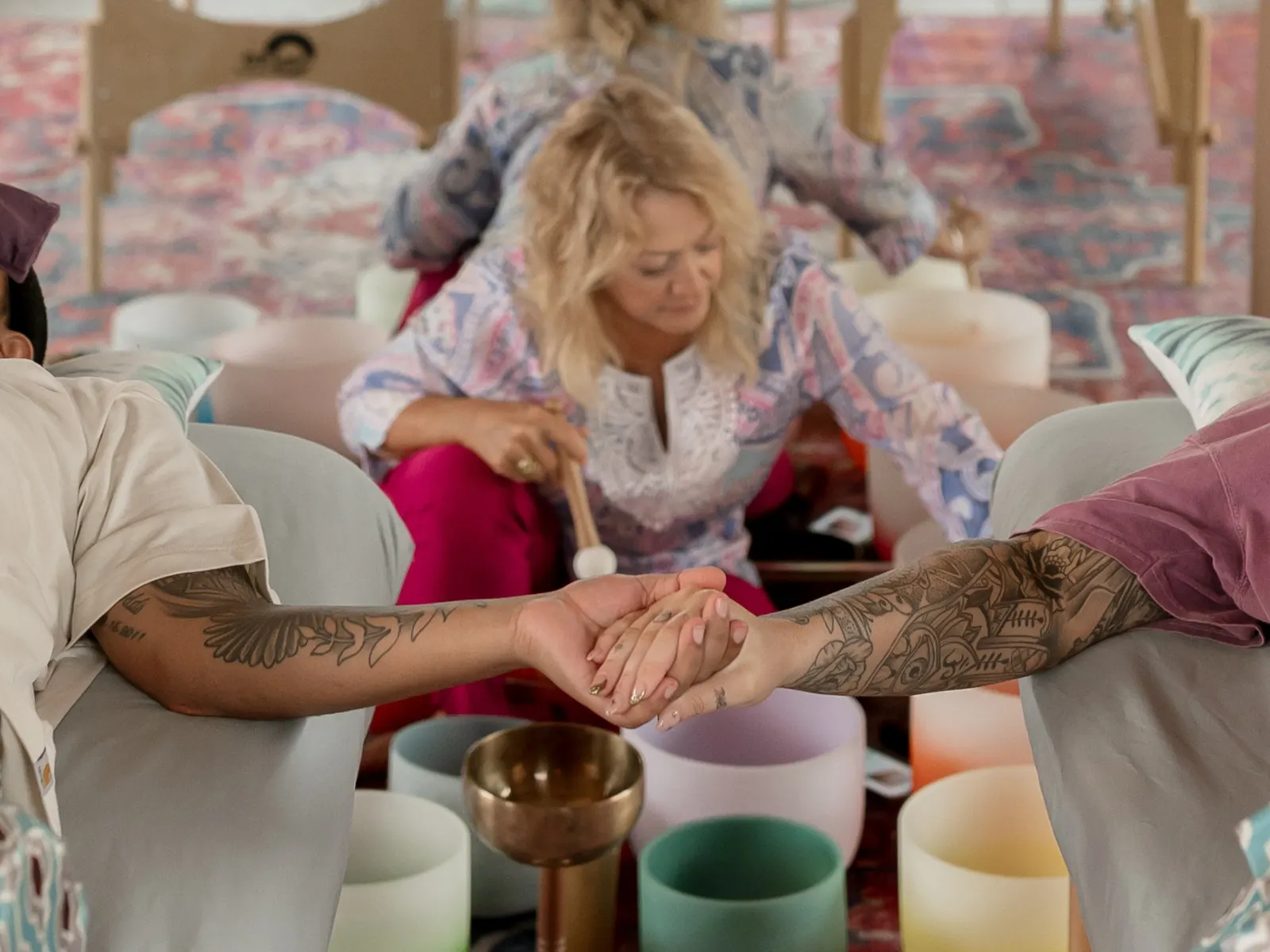 Couple's Sound Bath Melina playing crystal bowls while a couple is holding hands